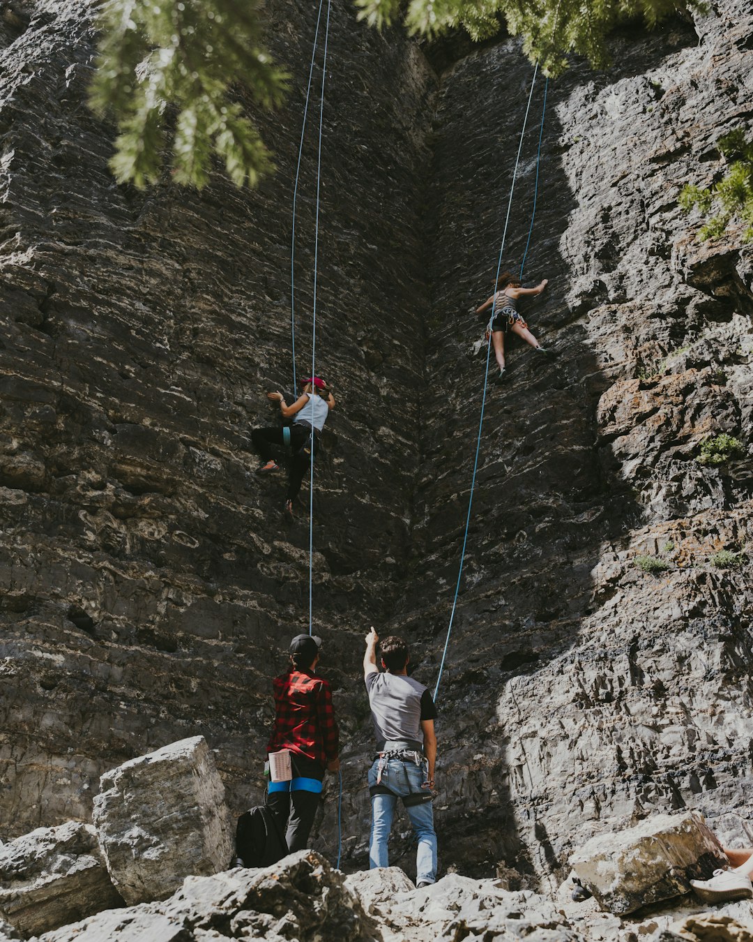 2 men climbing on rocky mountain during daytime