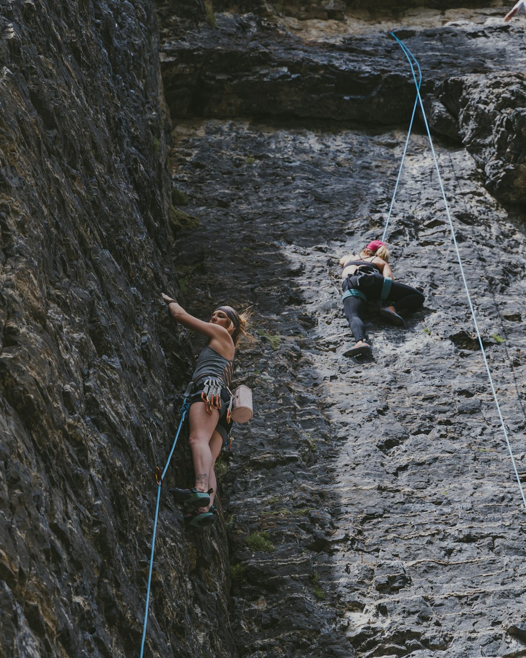 2 women in black and white bikini sitting on hanging bridge