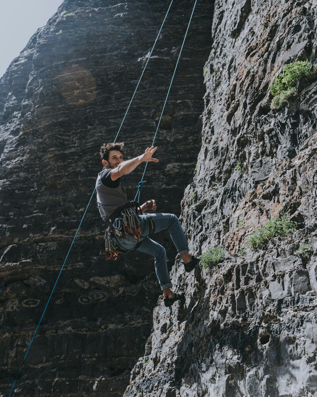 man in blue shorts climbing on rock