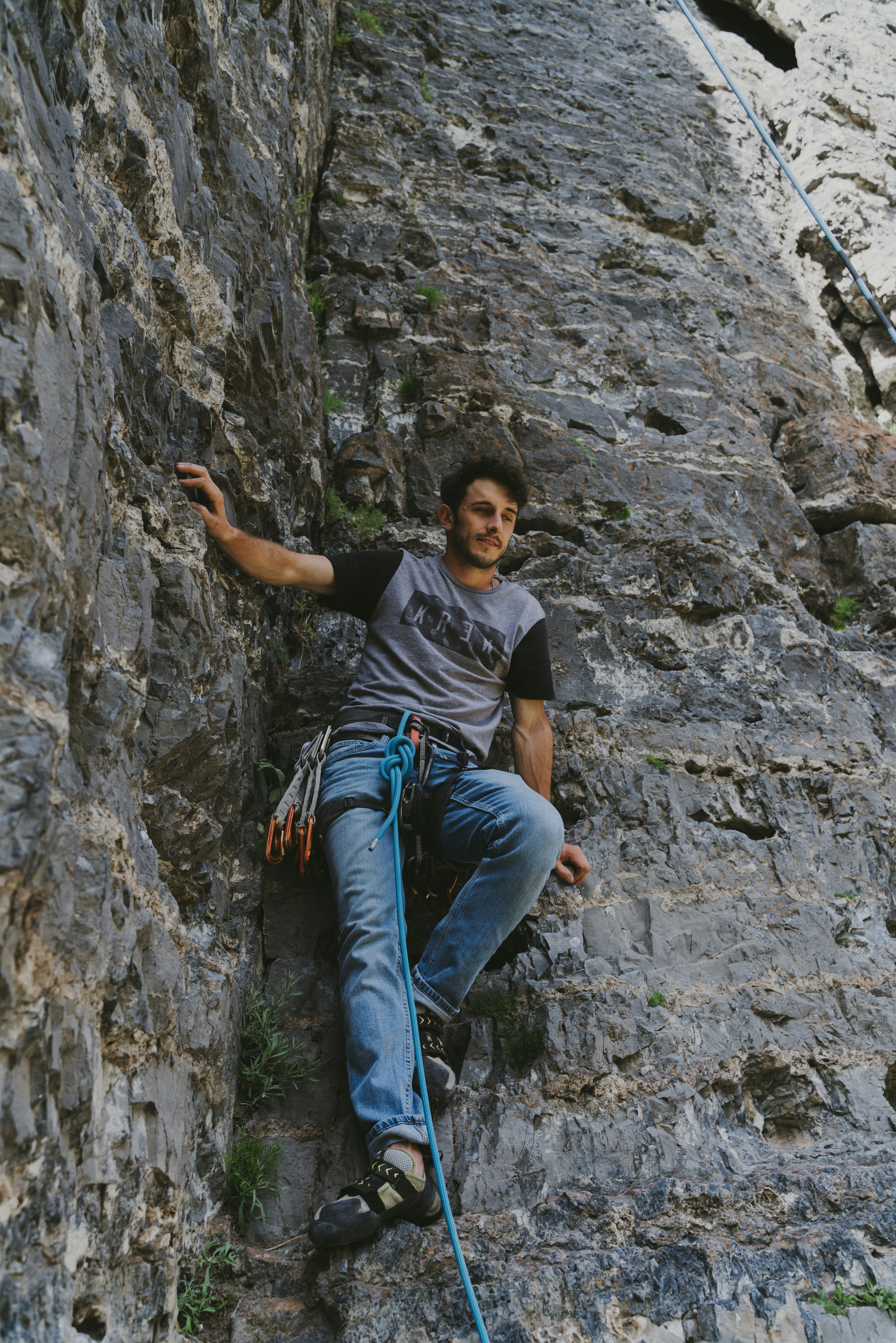 man in black crew neck t-shirt and blue denim jeans sitting on rock during daytime