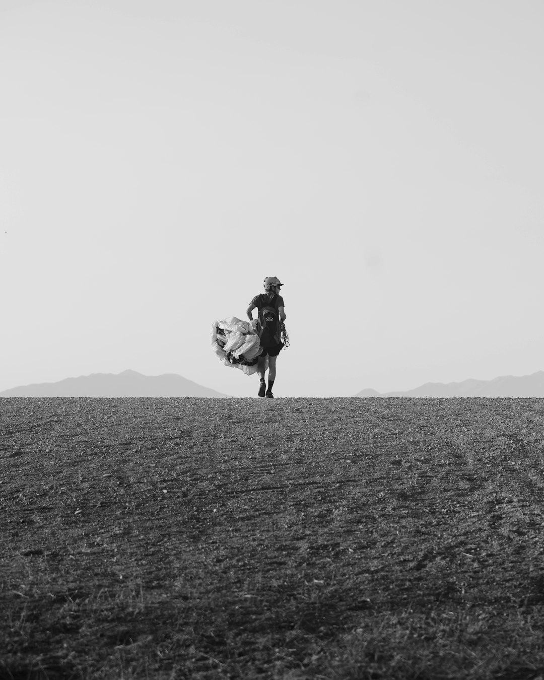 grayscale photo of man riding horse on field