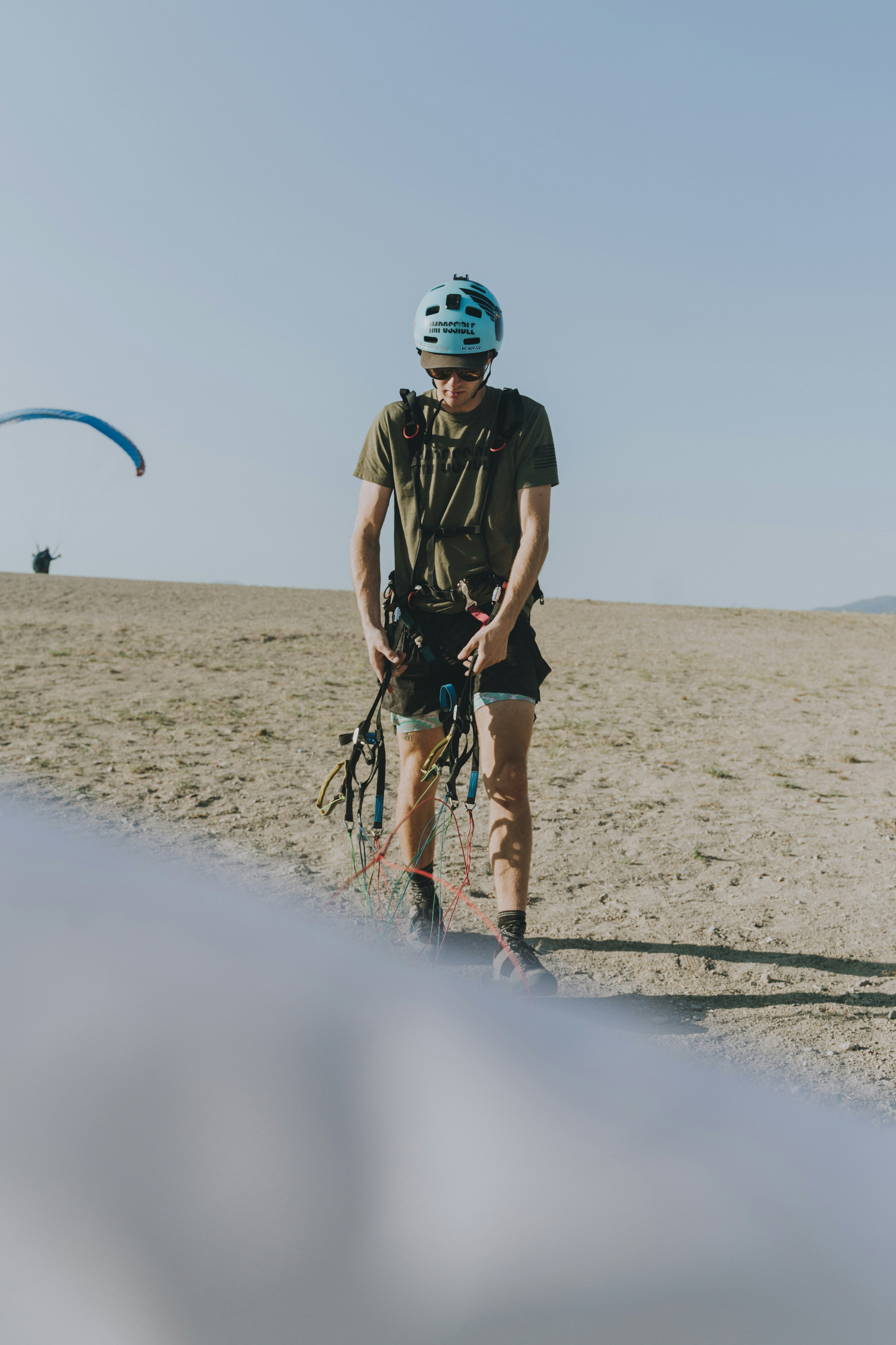 man in black and green camouflage shirt and shorts running on sand during daytime