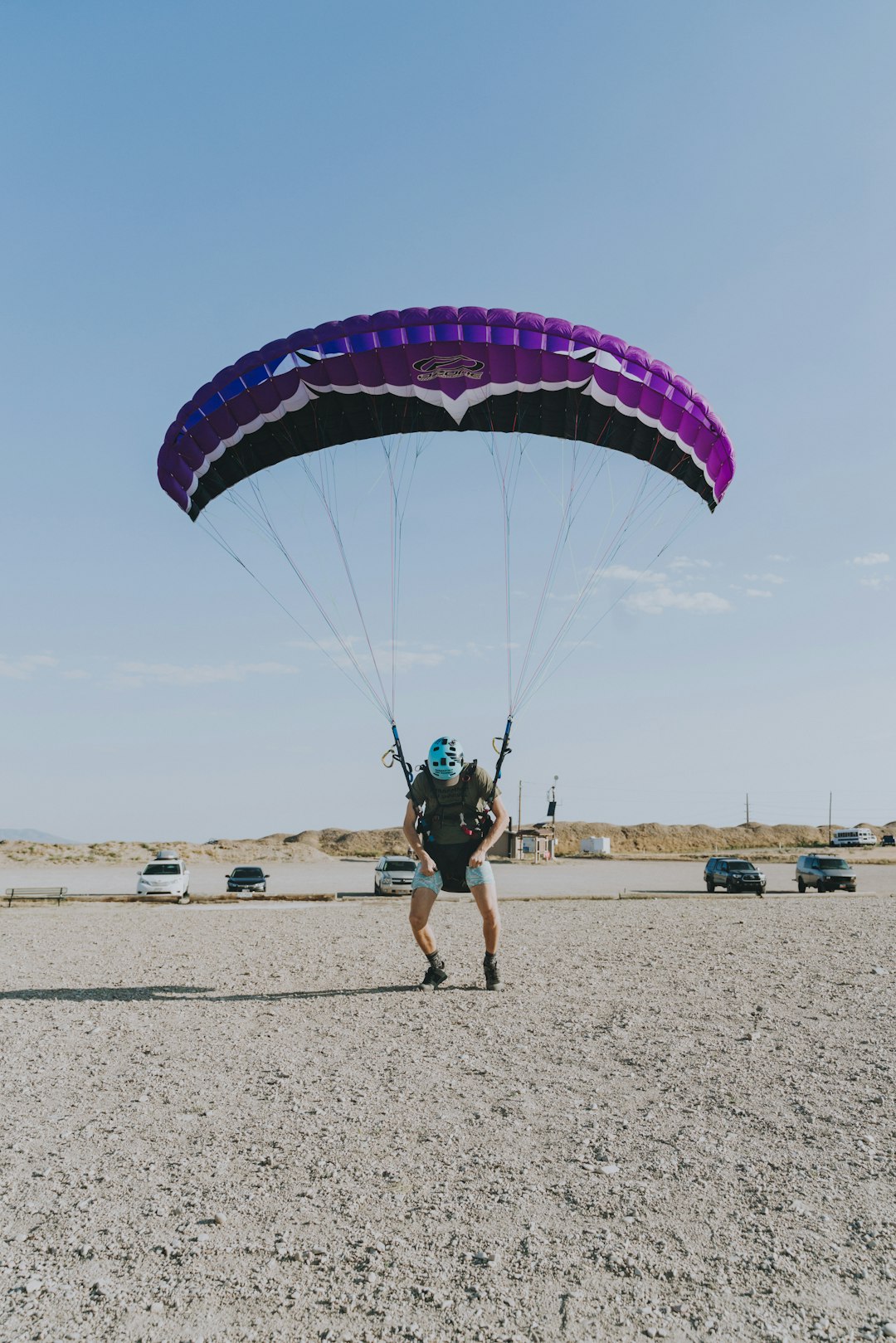 man in black shorts riding on blue and yellow parachute during daytime