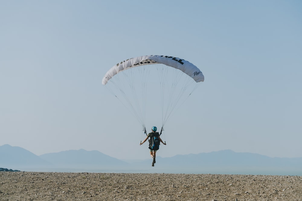 Hombre con camisa negra y pantalones montando en paracaídas
