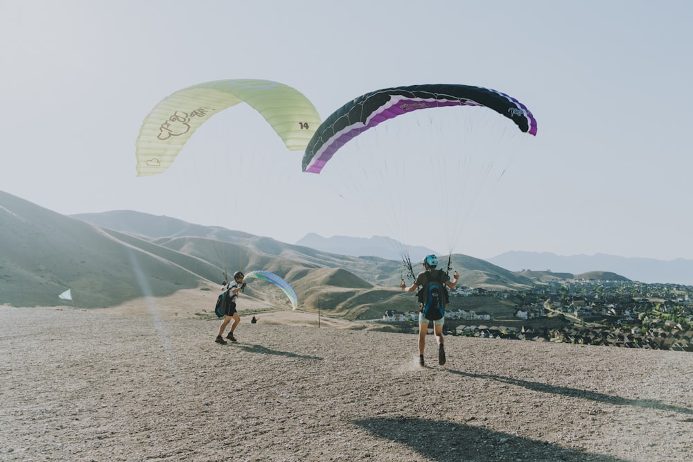 people on beach with parachute during daytime