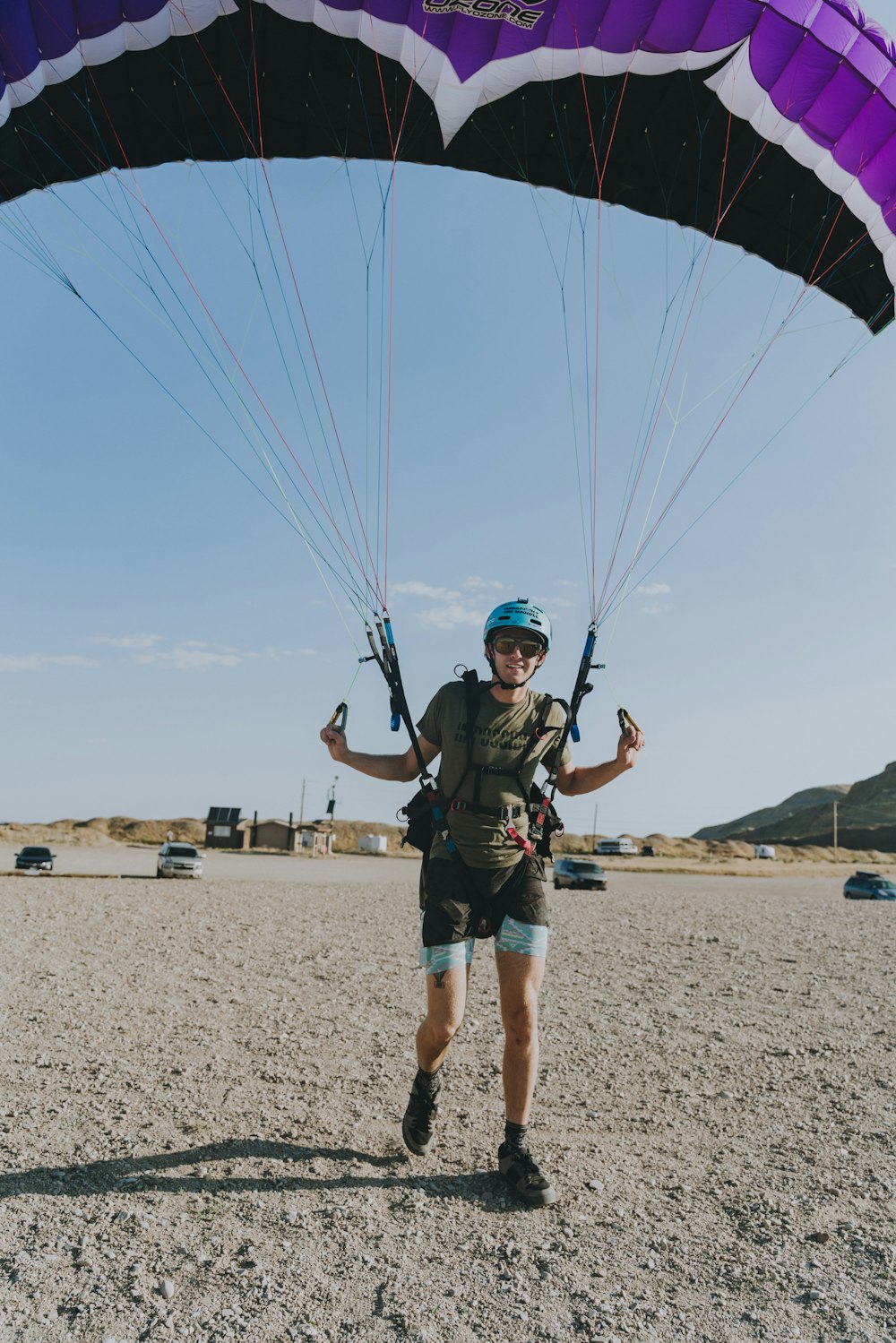 man in green jacket and blue shorts holding a yellow and blue parachute