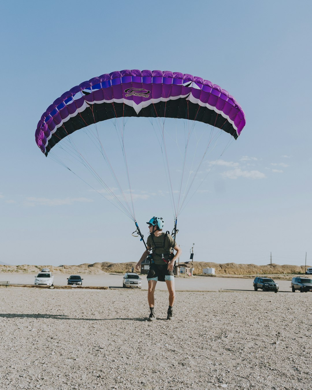 man in black shirt and shorts riding on blue and white parachute