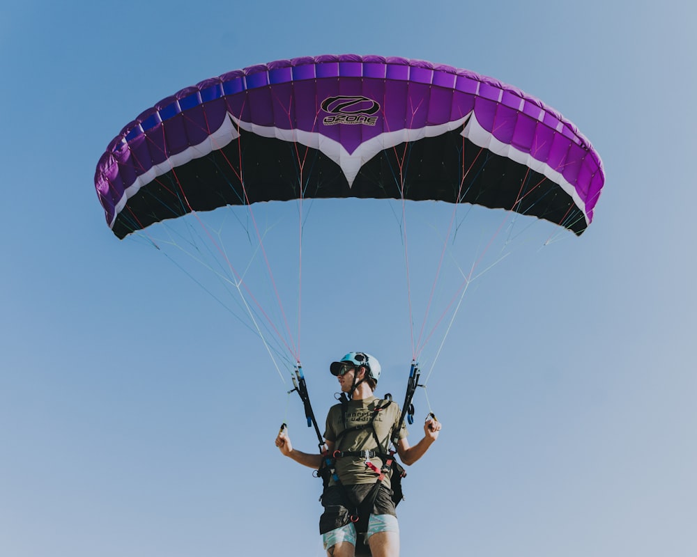 man in black jacket and pants riding parachute