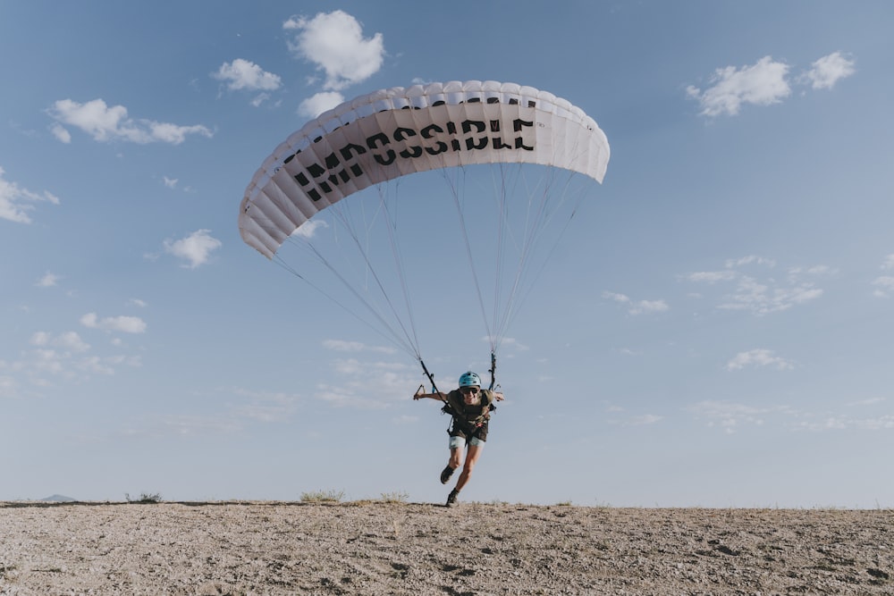 Hombre con camisa negra montando en paracaídas durante el día
