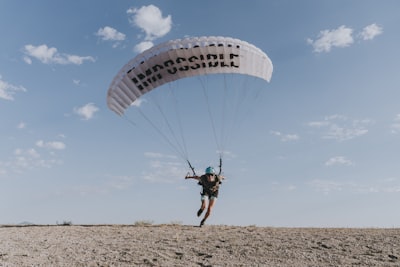 man in black shirt riding parachute during daytime impossible google meet background