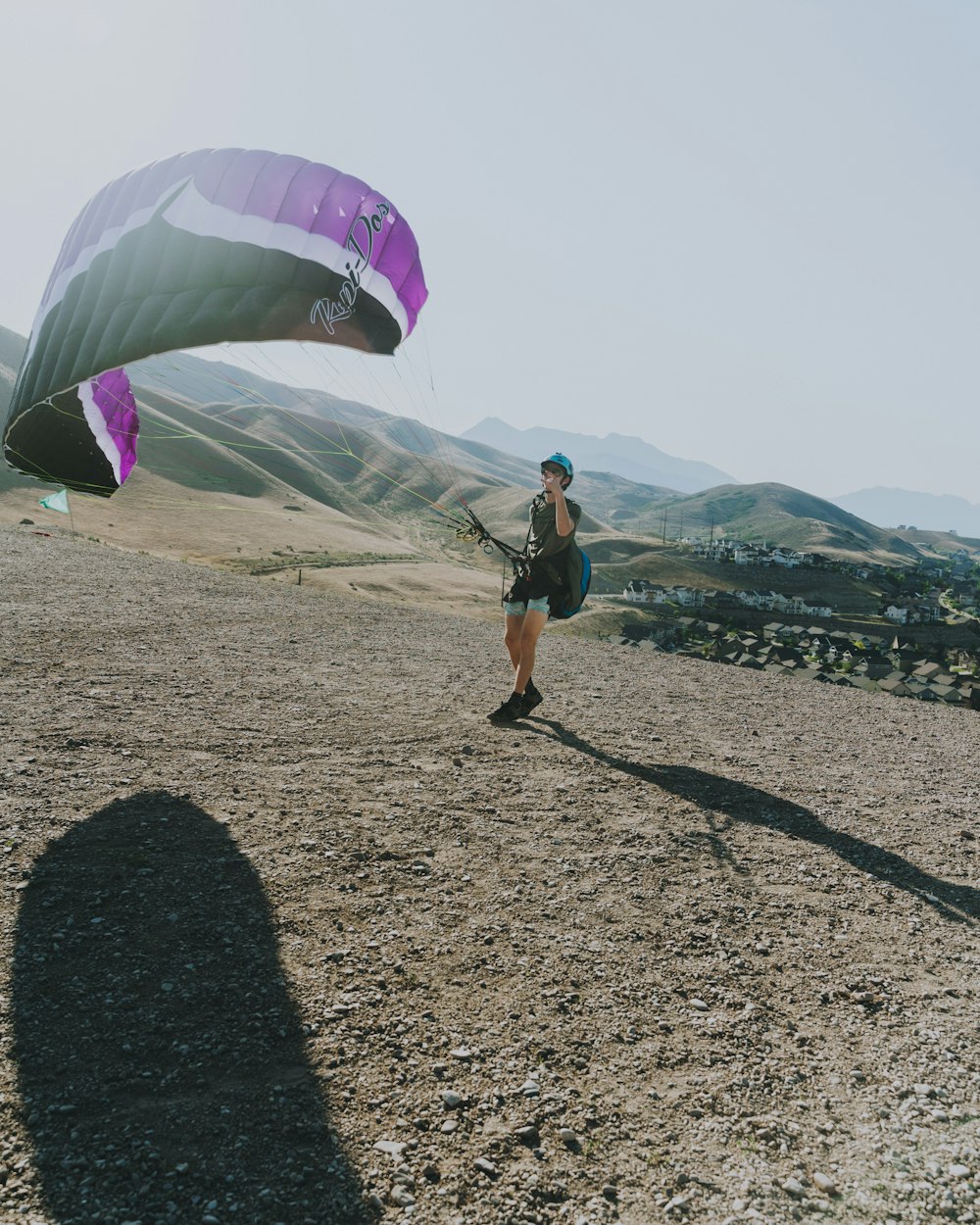 man in black t-shirt and black shorts holding purple and white parachute