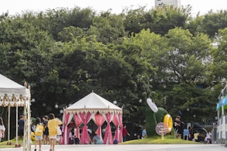 A lively outdoor literary festival scene with families, students, and authors engaging in reading activities under colorful tents.