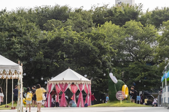A lively outdoor literary festival scene with families, students, and authors engaging in reading activities under colorful tents.
