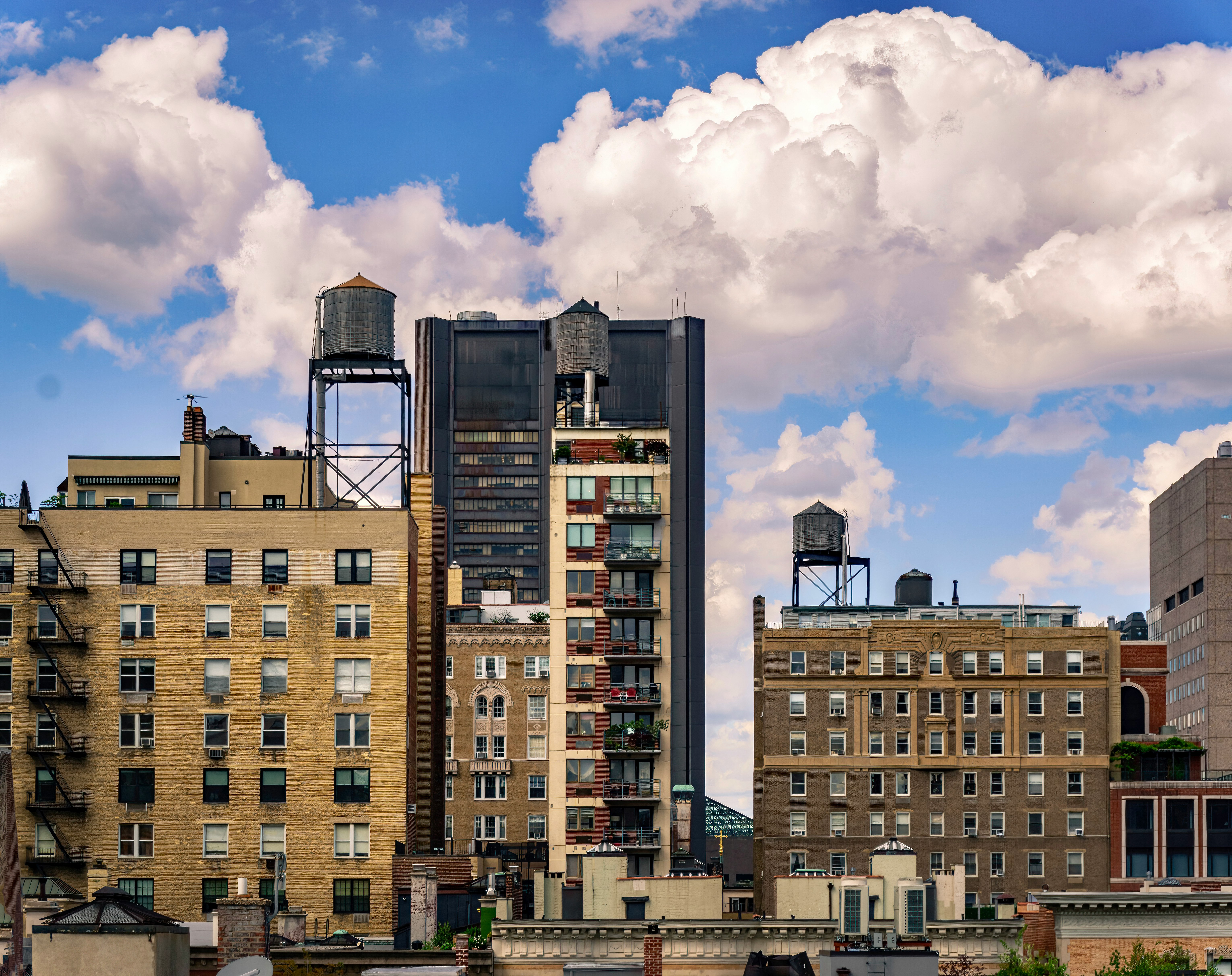 brown concrete building under white clouds and blue sky during daytime