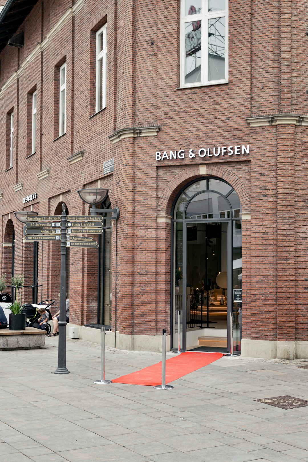 people walking on sidewalk near brown concrete building during daytime