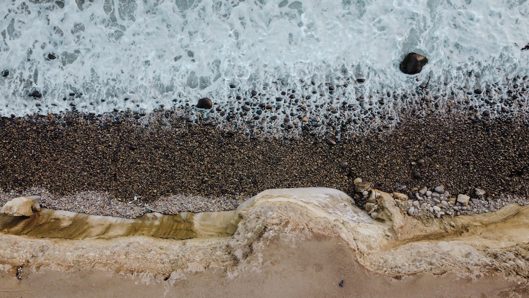 brown sand near body of water during daytime