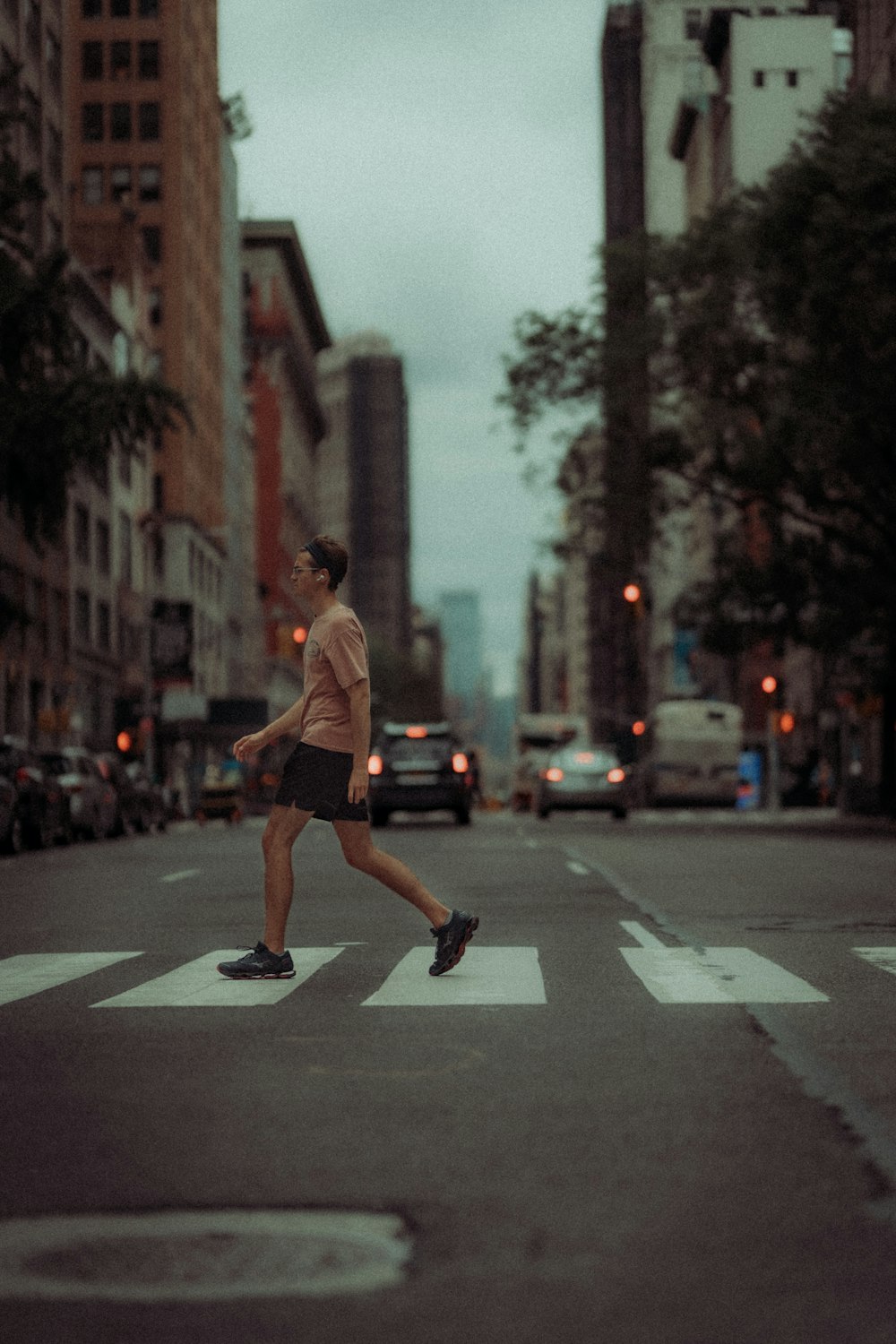 man in brown shirt and black shorts running on road during daytime