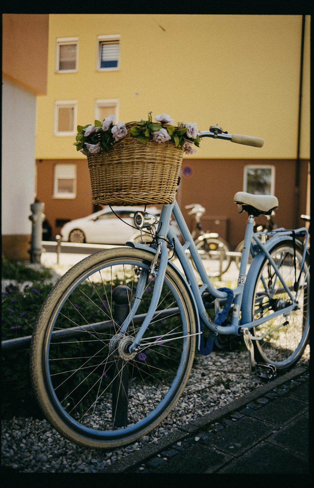 blue city bike with basket of flowers