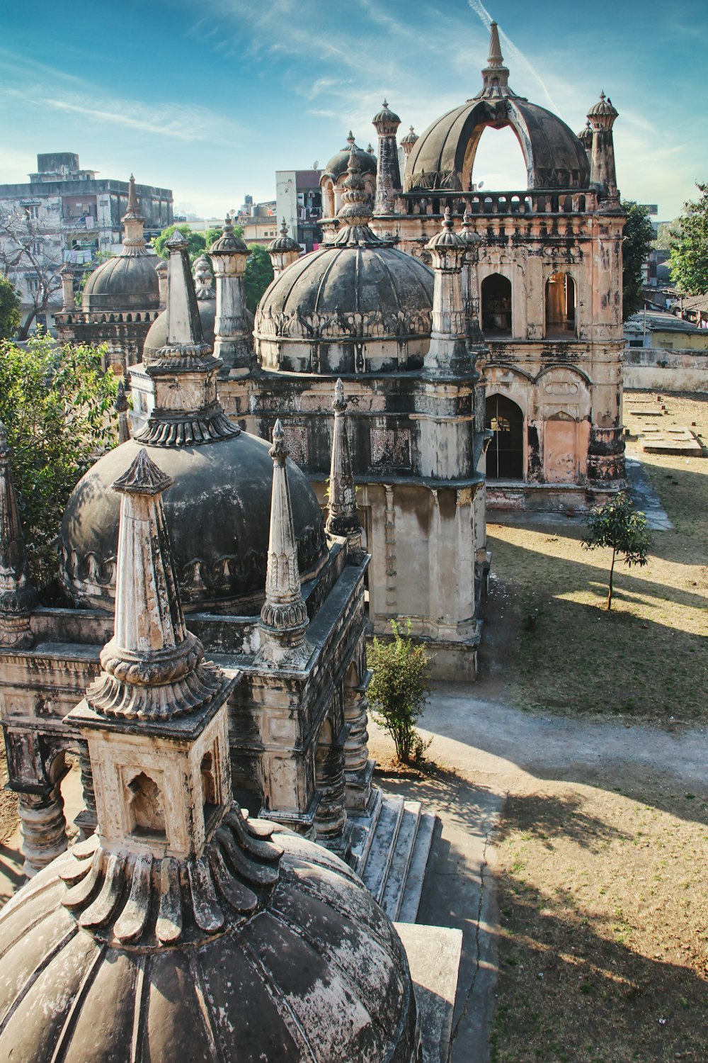 edificio in cemento grigio vicino agli alberi verdi durante il giorno