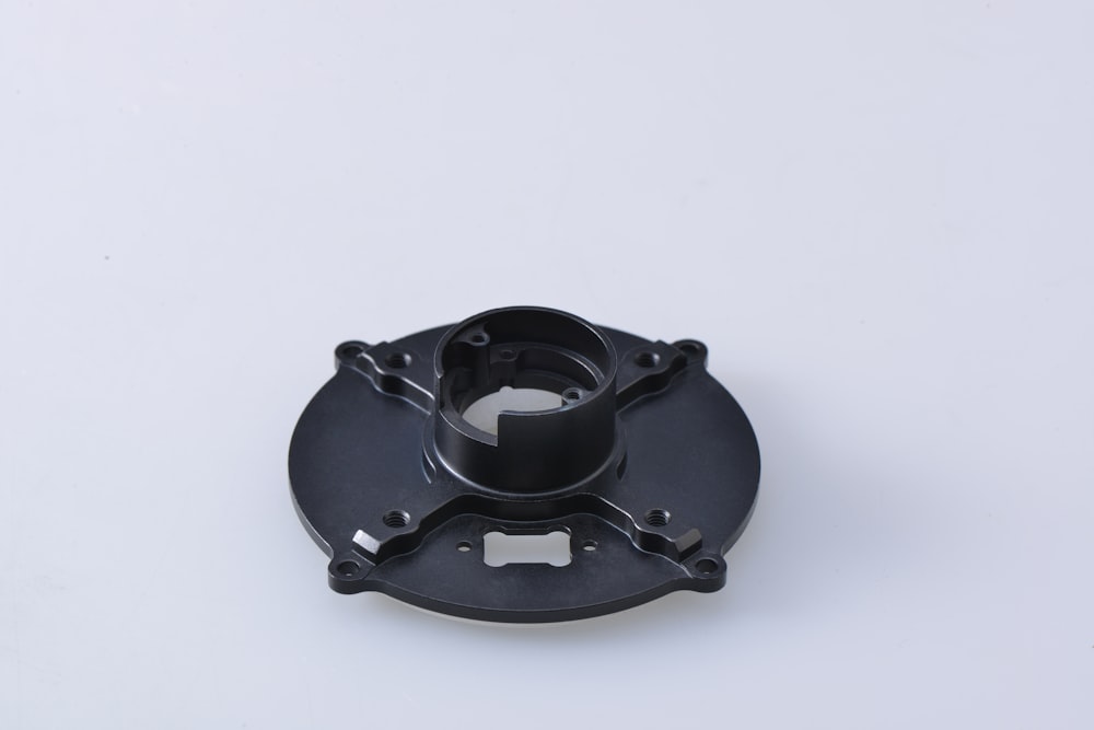black round metal tool on white surface