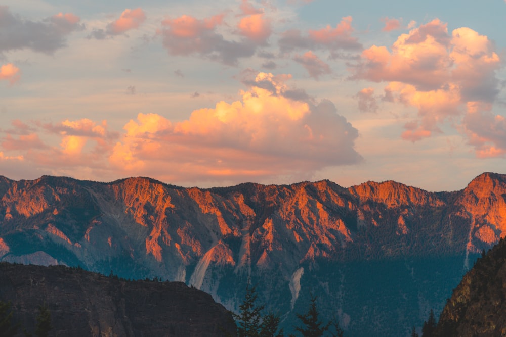 montagne rocheuse brune sous ciel nuageux pendant la journée