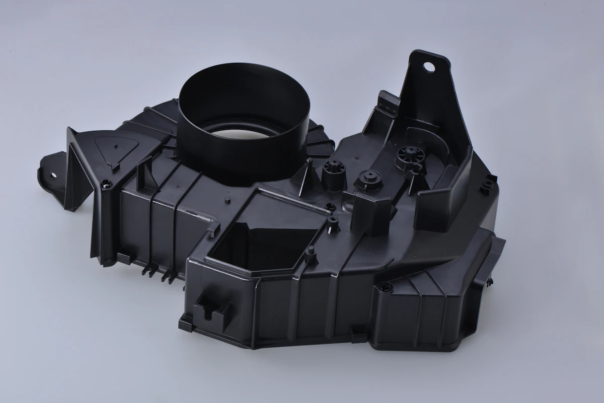 A dark molded housing with a circular collar and bracket lugs