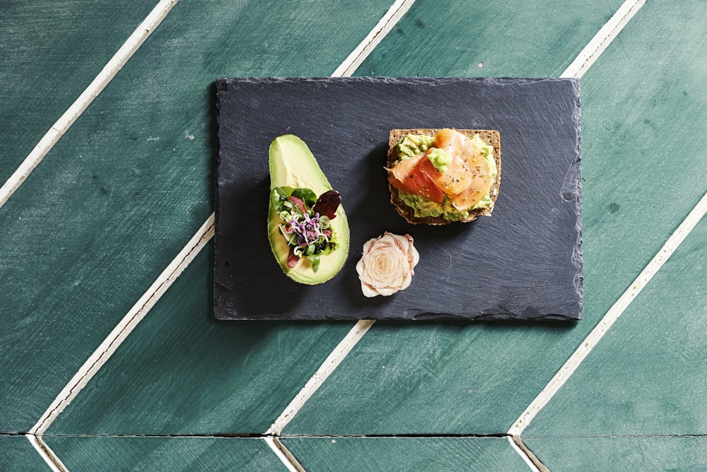 sliced avocado fruit on blue wooden chopping board