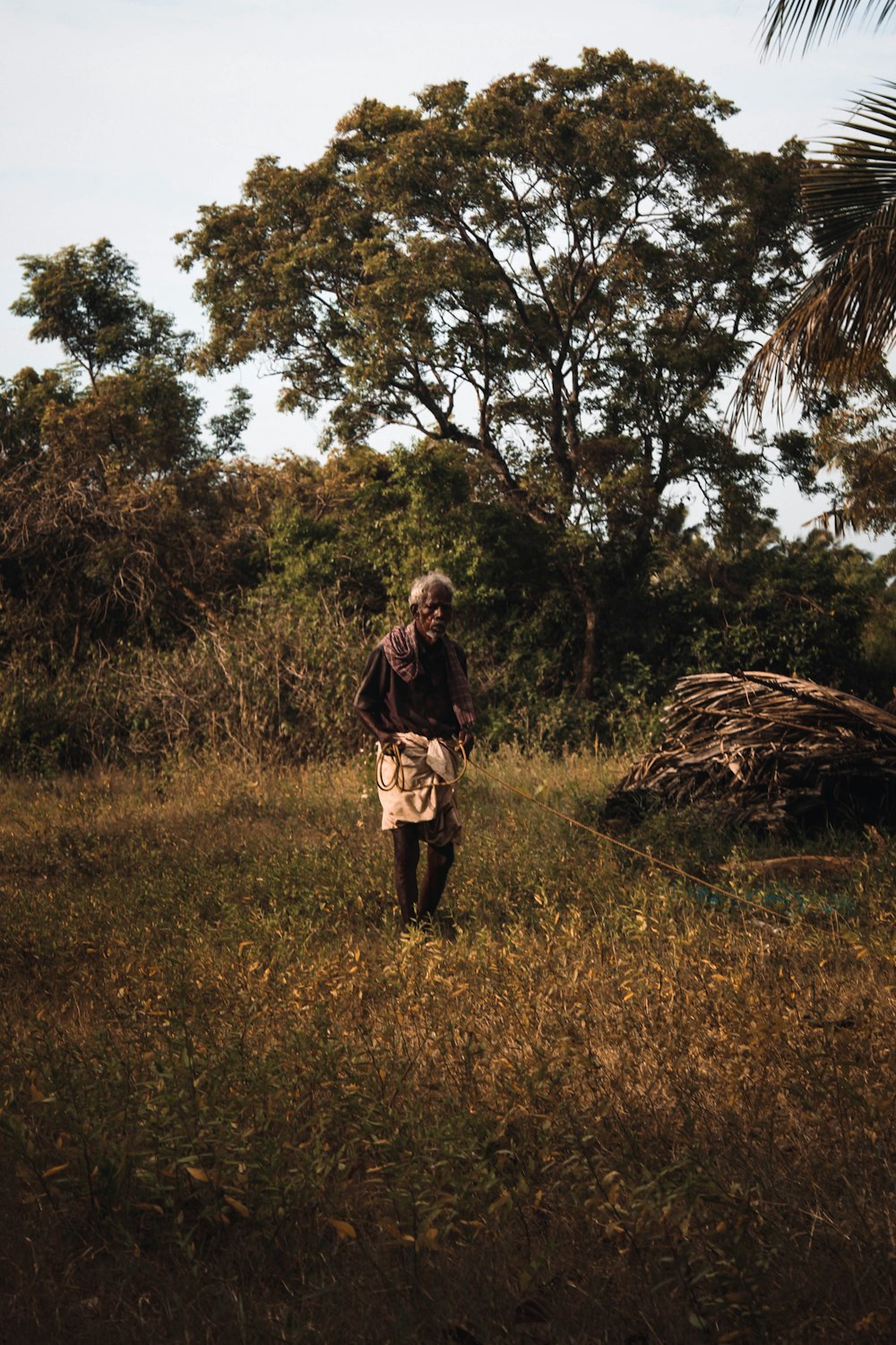 Mujer en chaqueta marrón de pie en el campo de hierba marrón durante el día