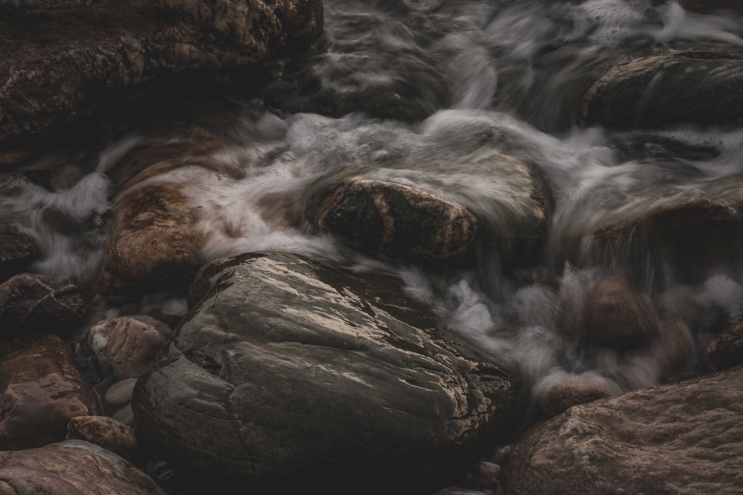 water falls on brown rocky mountain during daytime