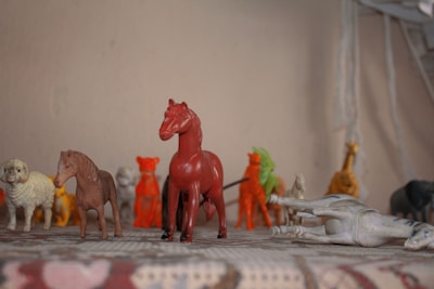 A set of vibrant plastic animal figurines lined up on a white surface.