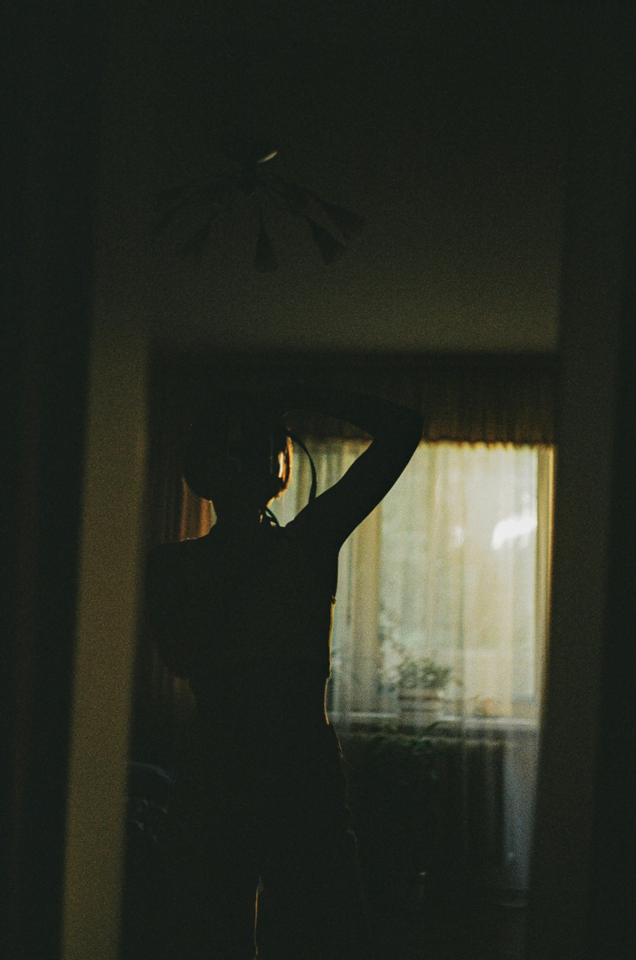 woman in black tank top standing near window