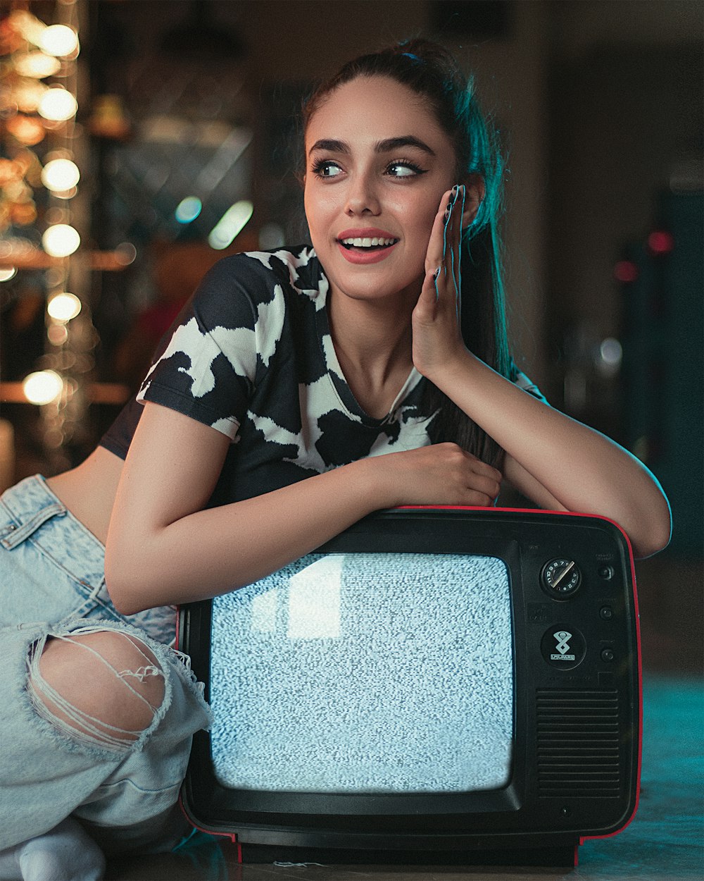 woman in black and white floral shirt and blue denim shorts sitting on chair