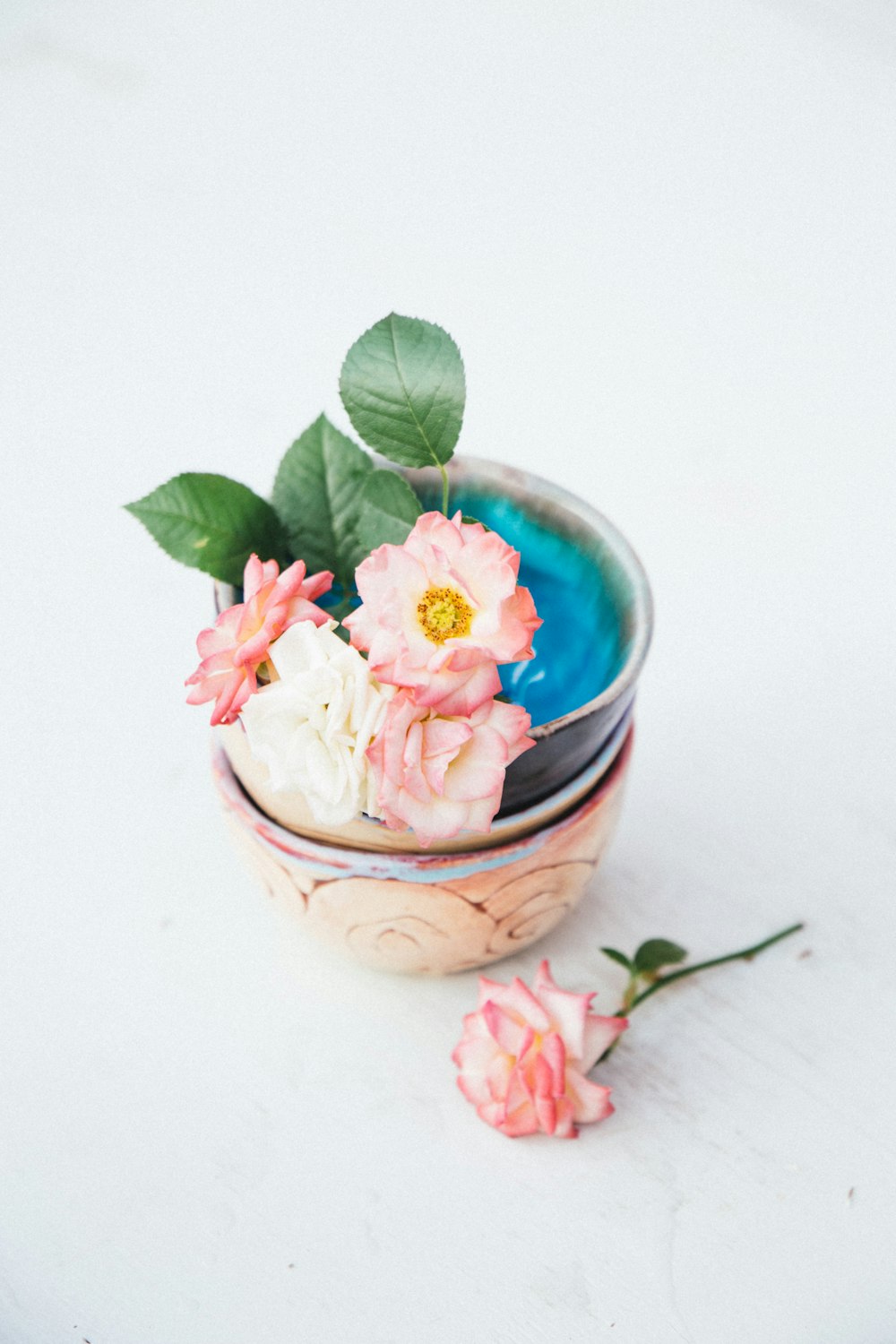 pink flower in blue glass bowl