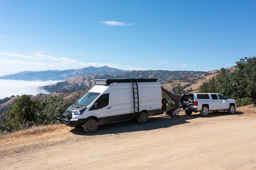 white van on brown dirt road during daytime