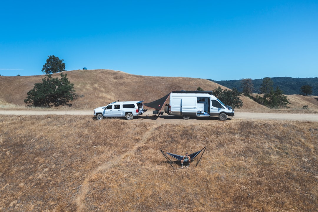 white crew cab pickup truck on brown field during daytime