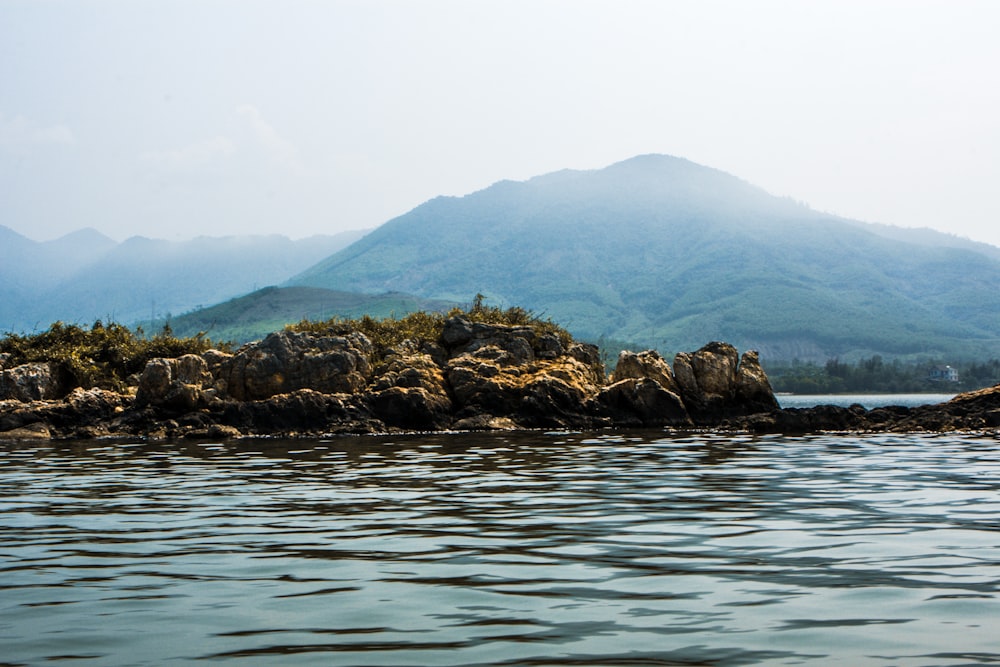 brown rock formation on body of water during daytime