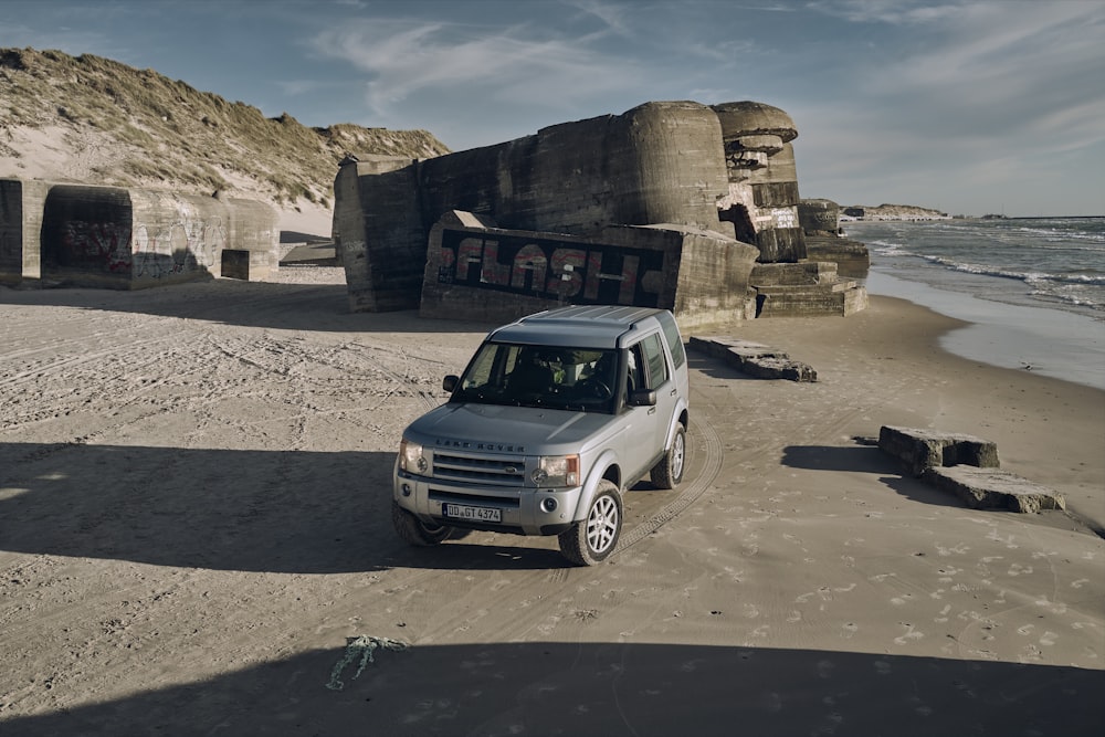 white suv parked on gray sand during daytime