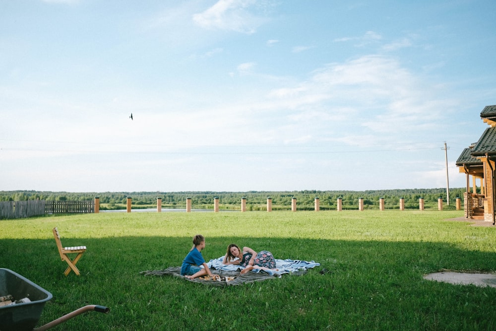 man and woman lying on green grass field during daytime