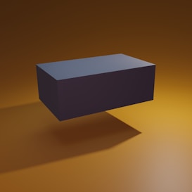 A dark rectangular block hovers in mid-air, casting a sharp shadow against a smooth, gradient background of warm amber tones.