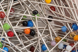 A variety of sewing needles and pins organized in a vintage tin box.