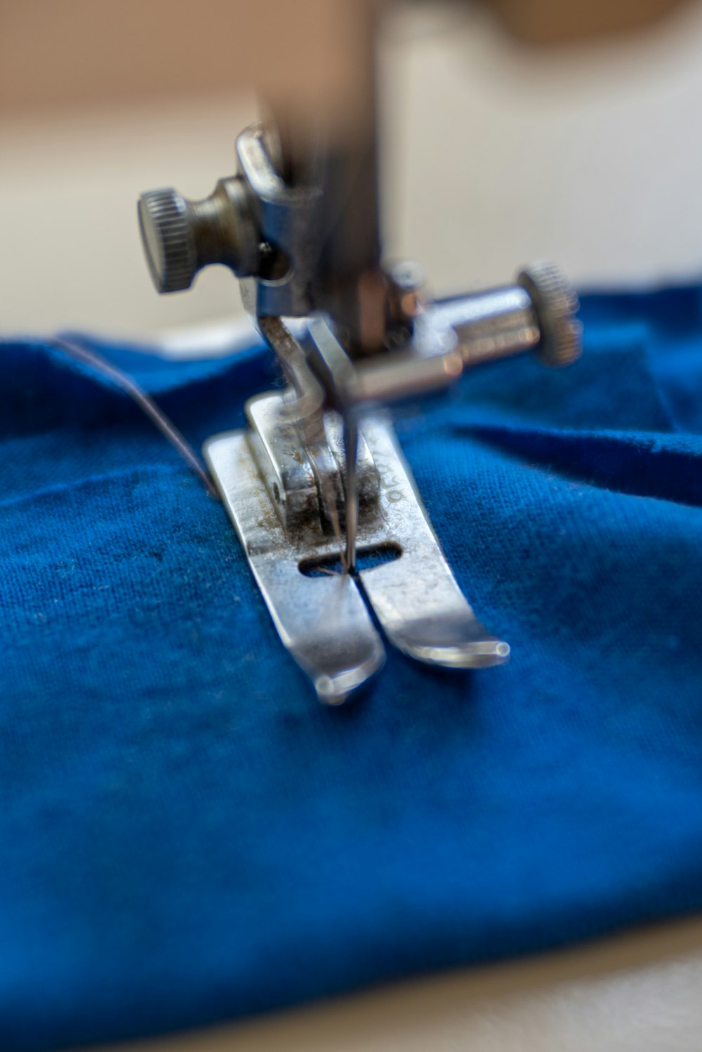 Silberne Nähmaschine auf blauem Textil