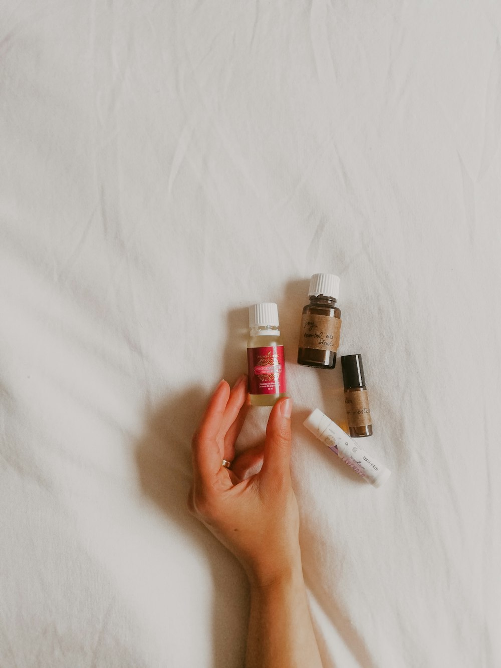 person holding white and red plastic bottles