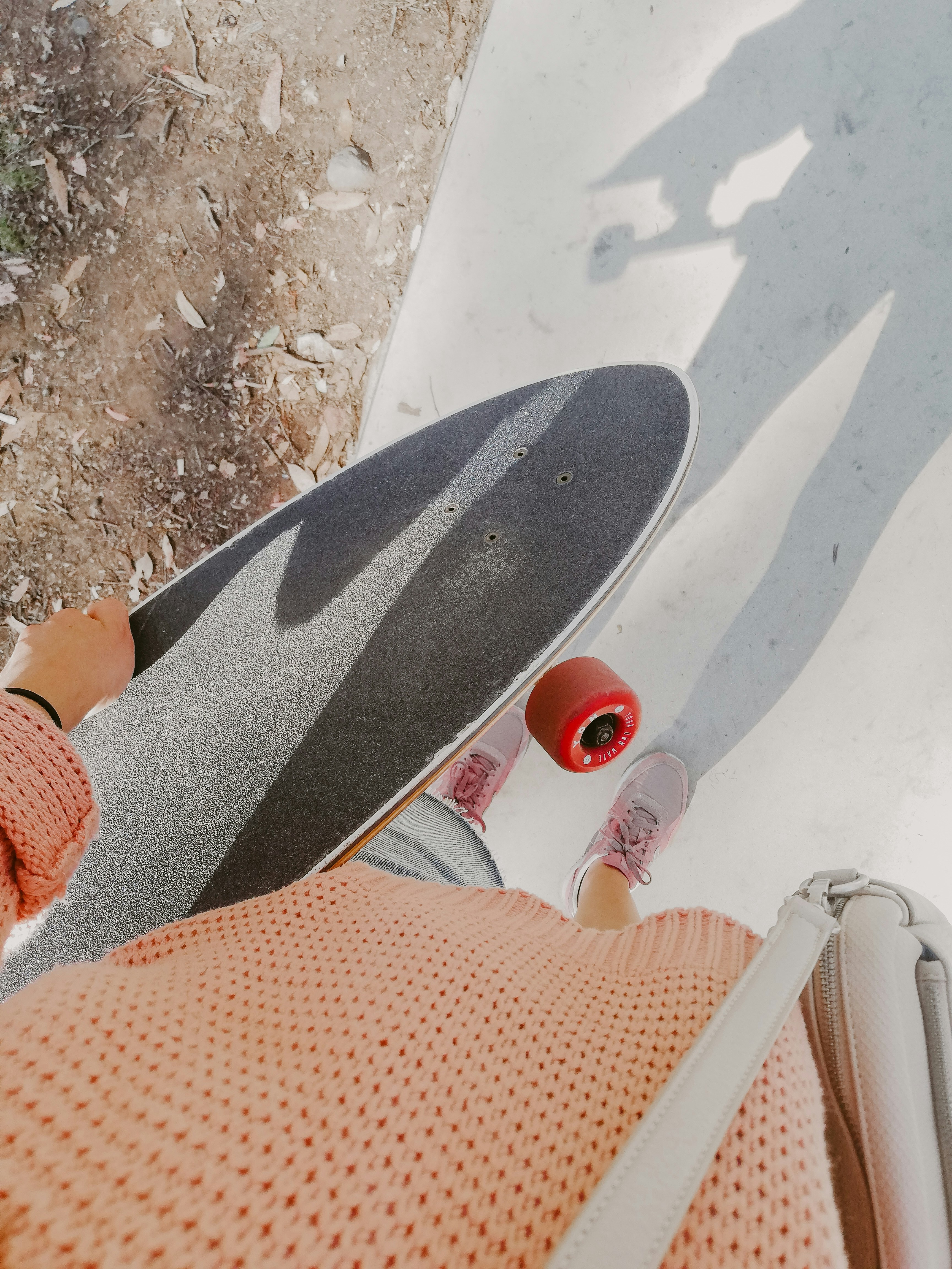 person in orange sweater and black pants sitting on white chair