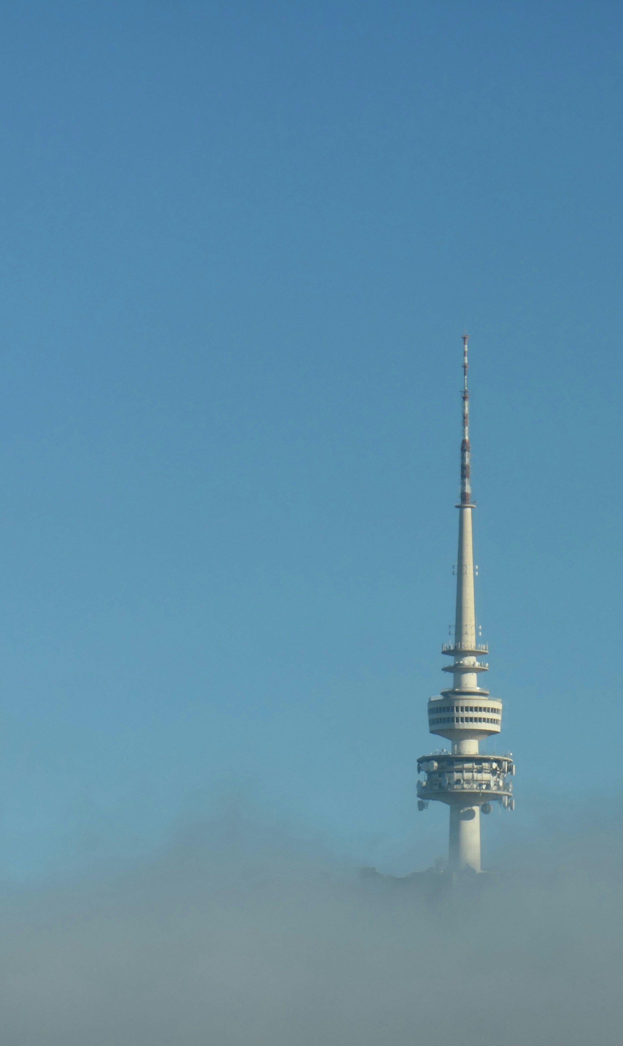 torre de concreto branca e preta sob o céu azul durante o dia
