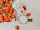 Fraises posées sur un pot de yaourt