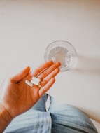 person holding white medication pill