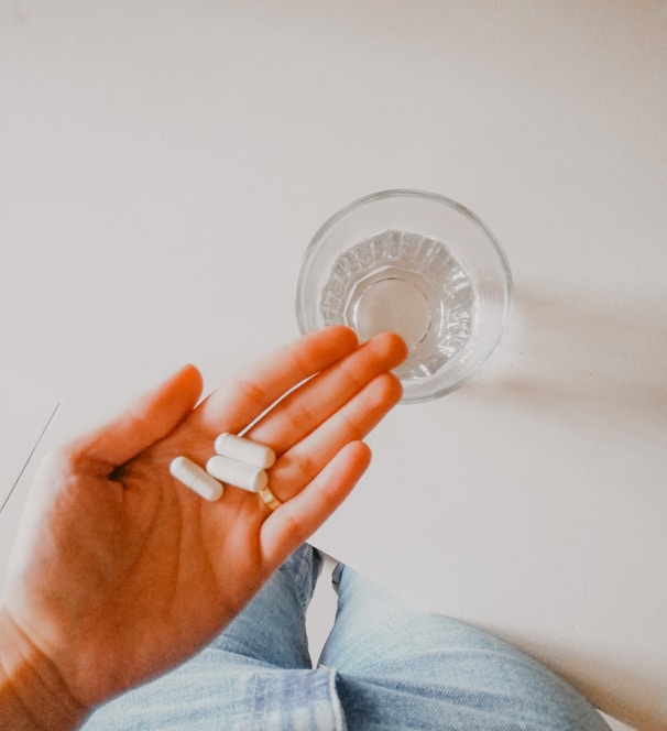 person holding white medication pill