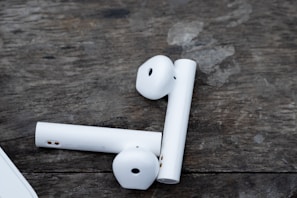 Compact and modern wireless earbuds resting on a wooden surface