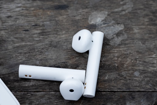 Wireless headphones resting on a simple wooden surface