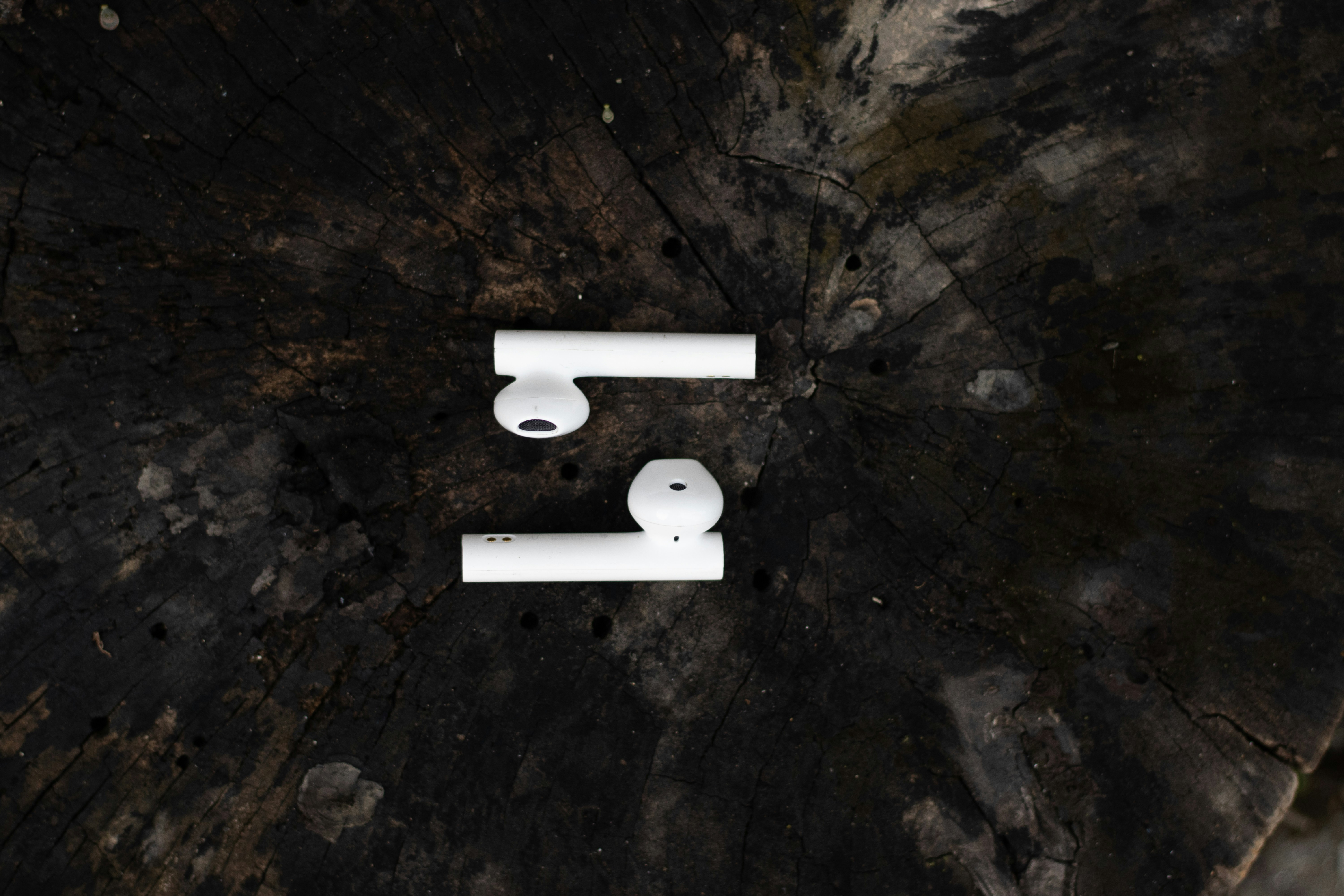 Wireless Bluetooth headphones on wooden background with a moody environment.